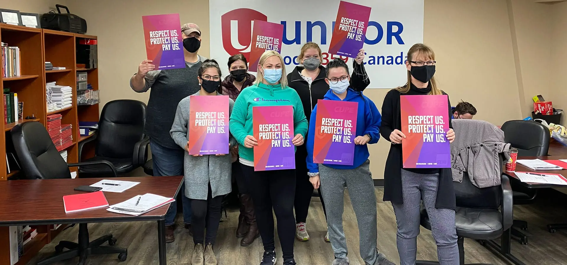 A group of people holding posters and posing for picture.